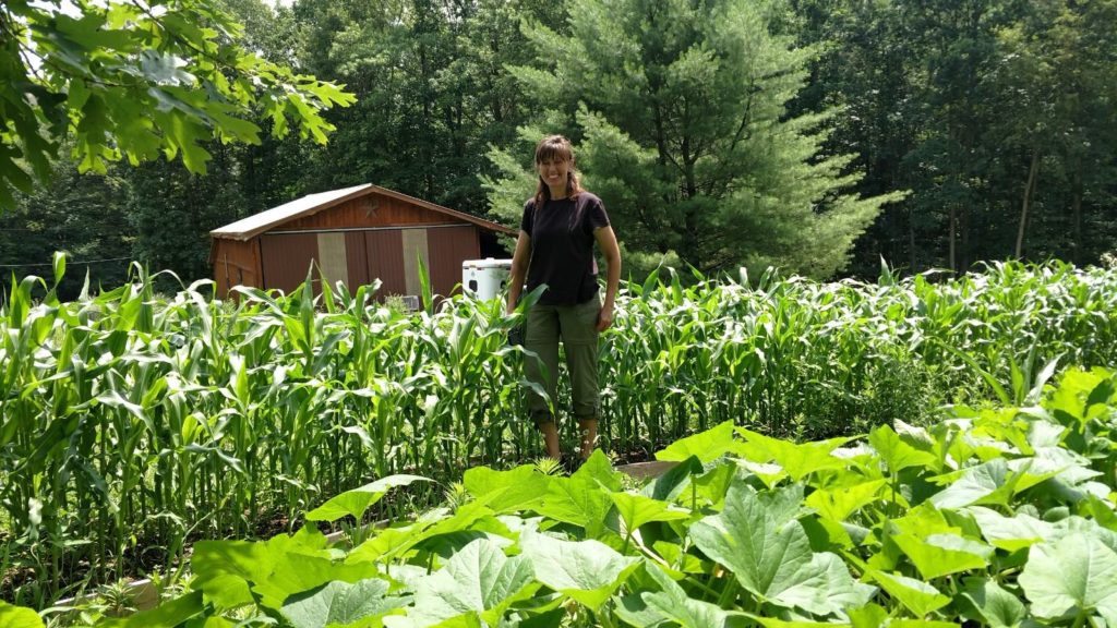 Bren standing in the raised bed gardens.