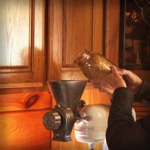 Pouring wheat berries into a grain mill